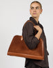Model carrying the cognac suede laptop work bag