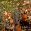 woman-surrounded-by-leather-bags-near-garden-table