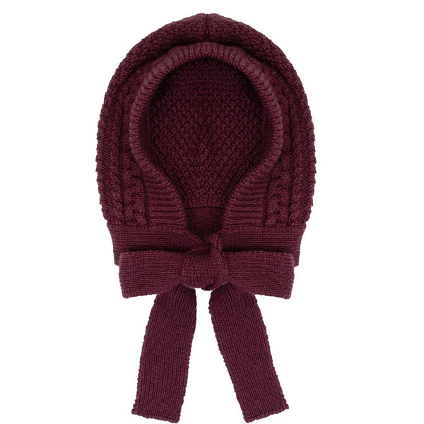 Knitted burgundy baby bonnet with a bow on a white background